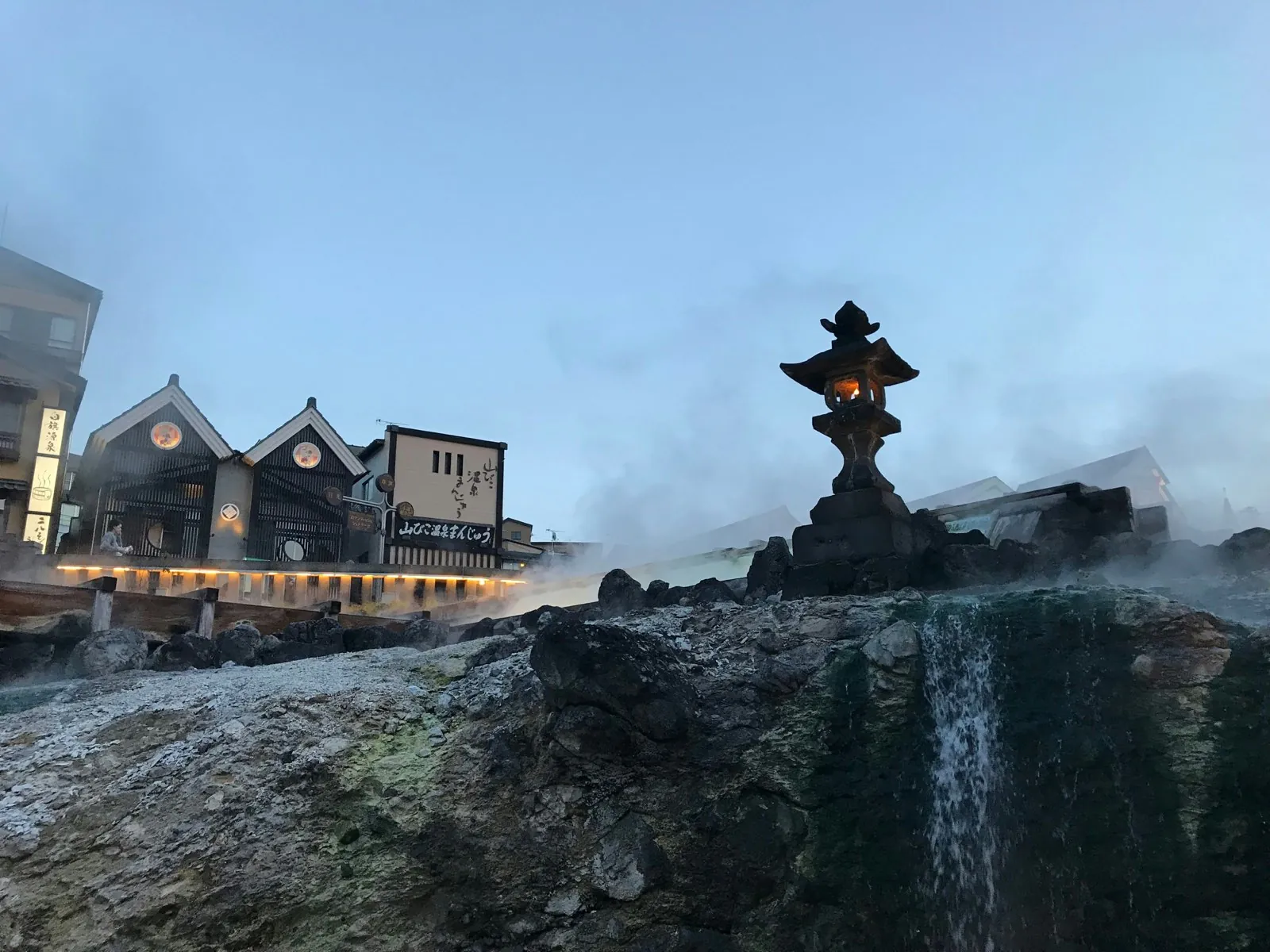 Dampend thermaalwaterveld Yubatake met een stenen lantaarn in Kusatsu Onsen